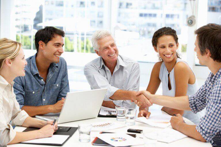 Eleves en formation autour d'une table discutant du leadership d'influence chez MP-Plus