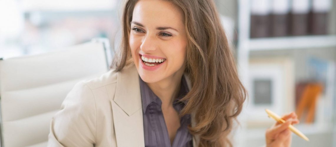 Portrait of happy business woman sitting in office